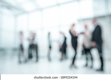 background image of company employees standing in the office lobby.