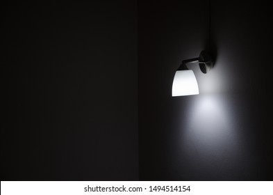 The background image of a day light lamp at the gray wall in the dark room and copy space on the left side.