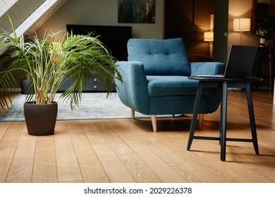 Background image of elegant home interior with focus on bold blue armchair and laptop, copy space