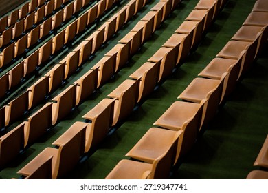 Background image of empty stands with multiple rows and empty seats. Orange fan seats are empty. News about fans and watching sports from stands. Cheering on your favorite sports team at stadium