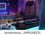 Background image of gaming setup in streamers studio room with focus on LED keyboard copy space