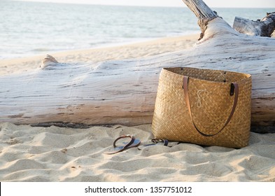 Background image of the hand made bag from natural like local Thai style with the slippers on the white sand at the beach on the holiday in Phuket.