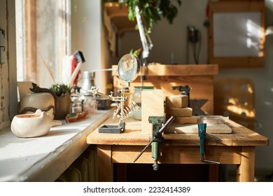 Background image of jewelers workstation with wooden table lit by sunlight in studio, copy space - Powered by Shutterstock