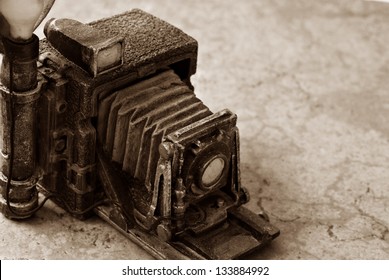 Background image of miniature vintage accordion style camera (model made from resin) on marbled tile.  Macro image in sepia tones with shallow dof and copy space. - Powered by Shutterstock