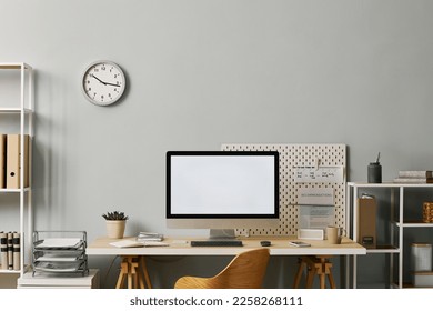 Background image of minima office setup with computer screen mockup on desk by pastel blue wall, copy space