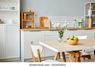 Background Image Of Minimal Kitchen Interior In White With Fresh Flowers And Fruits On Dinner Table, Copy Space