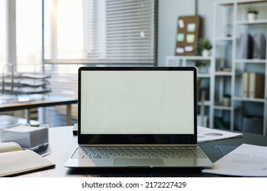 Background image of mock up computer with blank white screen in empty office interior, copy space