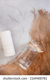 Background Image Of Mottled Grey Surface With Burlap And Clear Glass Jar And String With Copy Space