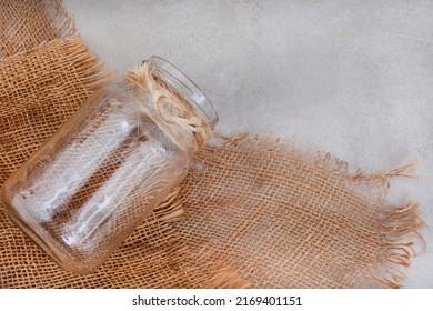 Background Image Of Mottled Grey Surface With Burlap And Clear Glass Jar With Copy Space