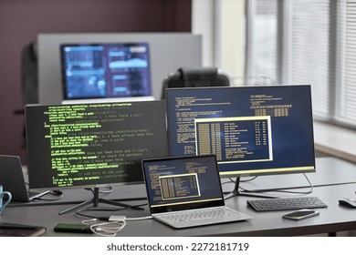 Background image of multiple computer screens with code lines at workplace desk in IT office