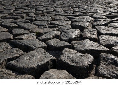 Background image of old cobblestone road backlit with low sunlight
