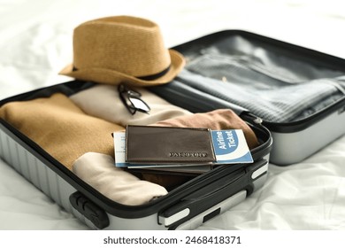 Background image of open suitcase with passport and airplane ticket on bed in hotel room travel concept