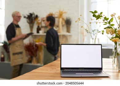 Background Image Of Opened Laptop With Blank White Screen In Flower Shop Small Business Interior, Copy Space