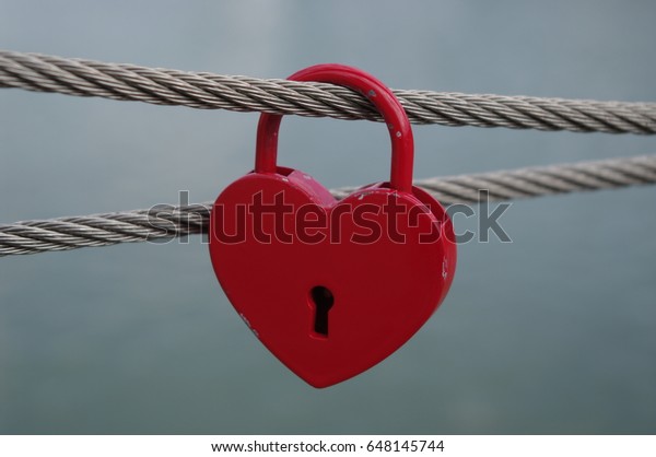 Background Image: Red Heart Padlock Hanging on a\
Wire Rope