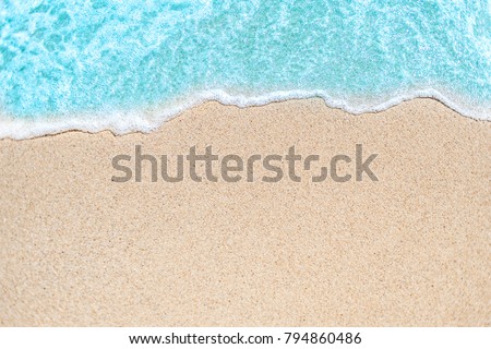 Background image of Soft wave of blue ocean on sandy beach.  Ocean wave close up with copy space for text