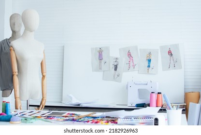 Background of interior tailor shop or room with nobody, there are mannequin, clothes, thread, sewing machine on table and paper of clothing design on wall. Lifestyle and small business concept - Shutterstock ID 2182926963