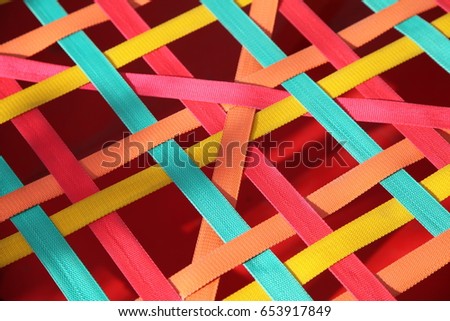 Background of intertwined multicolored textile ribbons
