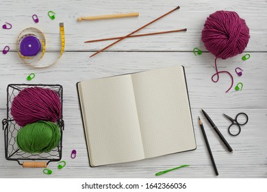 Background with knitting tools and accessories, colorful skein yarn and notebook, hobby concept