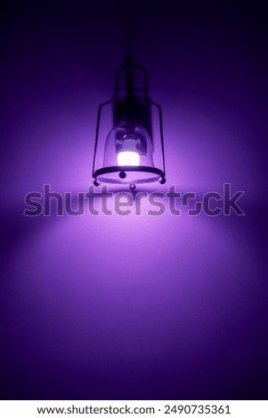 Background of a lamp casting light and shadow on the wall. Lamp light bulb on wall backdrop. Close up of illuminated wall with text space. vintage style design. Empty blank back lit wall. Dim room.