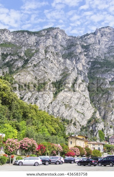 background landscape view of the waterfront city\
of Limone sul Garda with views of the mountains around Lake Garda,\
Italy, Trentino
