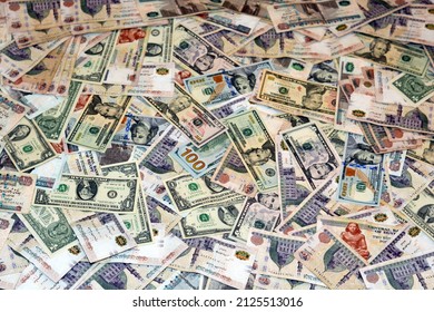 A background of large amount of American money banknotes with Egyptian money bills of different values, American dollars and Egyptian pounds currency exchange rate, stack of world banknotes