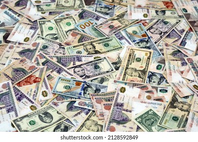 A background of large amount of American money banknotes with Egyptian money bills of different values, American dollars and Egyptian pounds currency exchange rate, stack of world banknotes