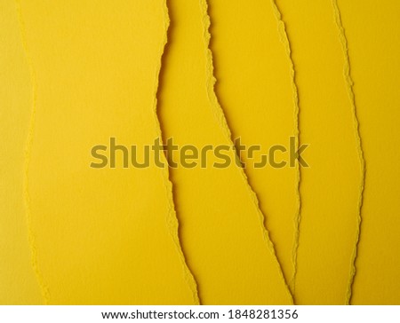 background of layered yellow torn paper with a shadow, backdrop and template for designer, close up