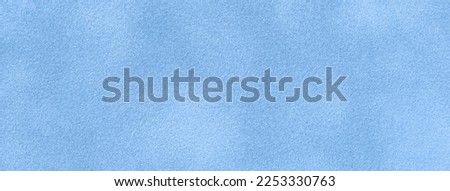 Background of light blue suede matte fabric closeup. Velvet matt texture of sky nubuck textile. Velveteen pattern. Structure of denim cloth, macro