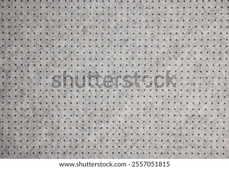 Background of light grey felt material with dark dots