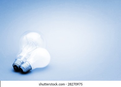 Background with lit lightbulb. Isolated on blue - Shutterstock ID 28270975