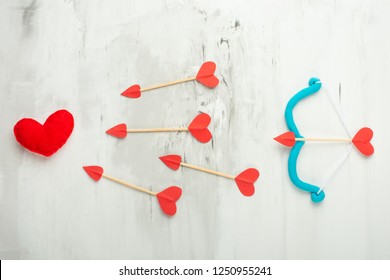 Background of lovers, arrows and cupid bow on a light background. Valentine's Day. Flat-lay, top view