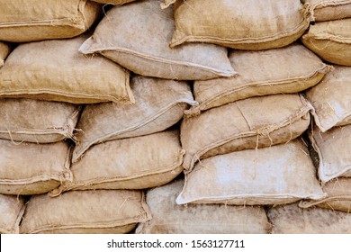 Background Of Lying Dirty Sandbags. Sandbag Flood Protection Wall Texture, Texture. Bags To Strengthen The Defensive Structure During The Battle.