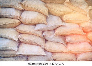 Background of lying grey sandbags. Sandbag flood protection wall texture. Bags to strengthen the defensive structure during the battle.