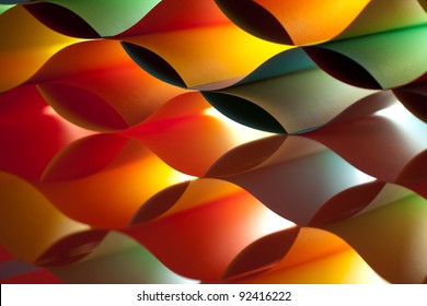 background macro image of colored origami pattern made of curved sheets of paper, with mirror reflexions