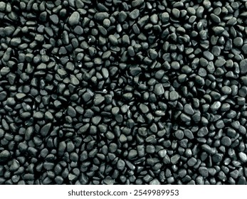 Background made of dark pebbles. Small fine gravel grains. Close up view of gravel pebbles from the top. Background of dark grey pebbles. Shiny black stones rocks. Black pebbles on the black stones. - Powered by Shutterstock