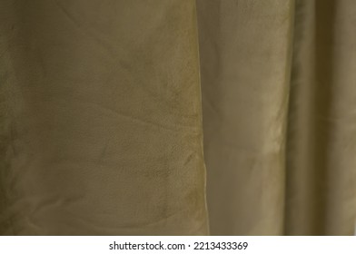 The Background Is Made Of Folds Of Olive-colored Curtains, The Material Is Corduroy. Soft Focus.