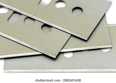 A background made from a macro photo of a pile of razor blades, isolated on a white background.