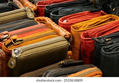 background of many colorful leather wallets with zippers handcrafted by a skilled artisan for sale in a leather goods store - Powered by Shutterstock