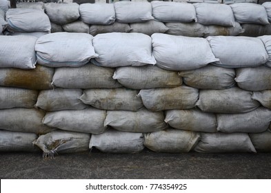 Background of many dirty sand bags for flood defense. Protective sandbag barricade for military use. Handsome tactical bunker