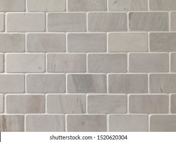 A Background Of Marble Tiles Arranged In A Subway Tile Pattern.