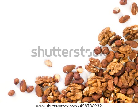 Background of mixed nuts - hazelnuts, walnuts, almonds - with copy space. Isolated one edge. Top view or flat lay