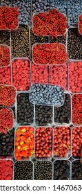 background of multicolored berries in boxes