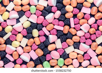 background of multi-colored candies on a dark background with copy space