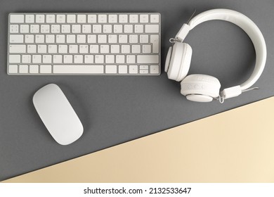 Background music or podcast with headphones and a computer keyboard on a gray table, flat. Top view, flat layout. 