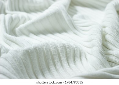 Background From Natural Fabric. Very Soft Knitted Cotton Of White Color With Stripes And Folds. The Surface Of Cotton Corrugated Blanket For Baby Borns Or Warming In Cold Weather. 
