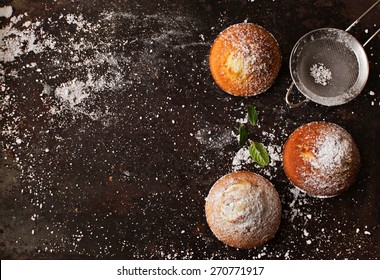 Background (old metal surface) with muffins and powdered sugar . Top view.