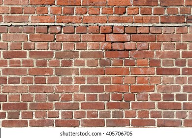 Background of old red brick wall with scratches, holes and gaps