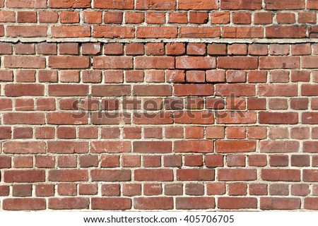 Background of old red brick wall with scratches, holes and gaps