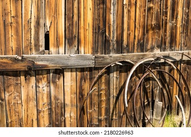 Background of old rusted wagon wheels against a weathered wood barn wall