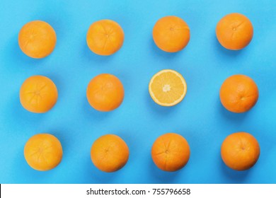 background of orange pattern, one oranges cut in half, top view, blue background, studio shot
